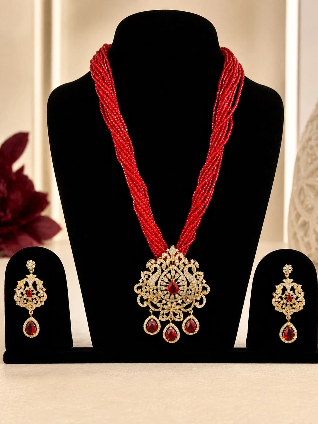 Sindoor red multi-strand bead necklace with an ornate crystal pendant and matching earrings