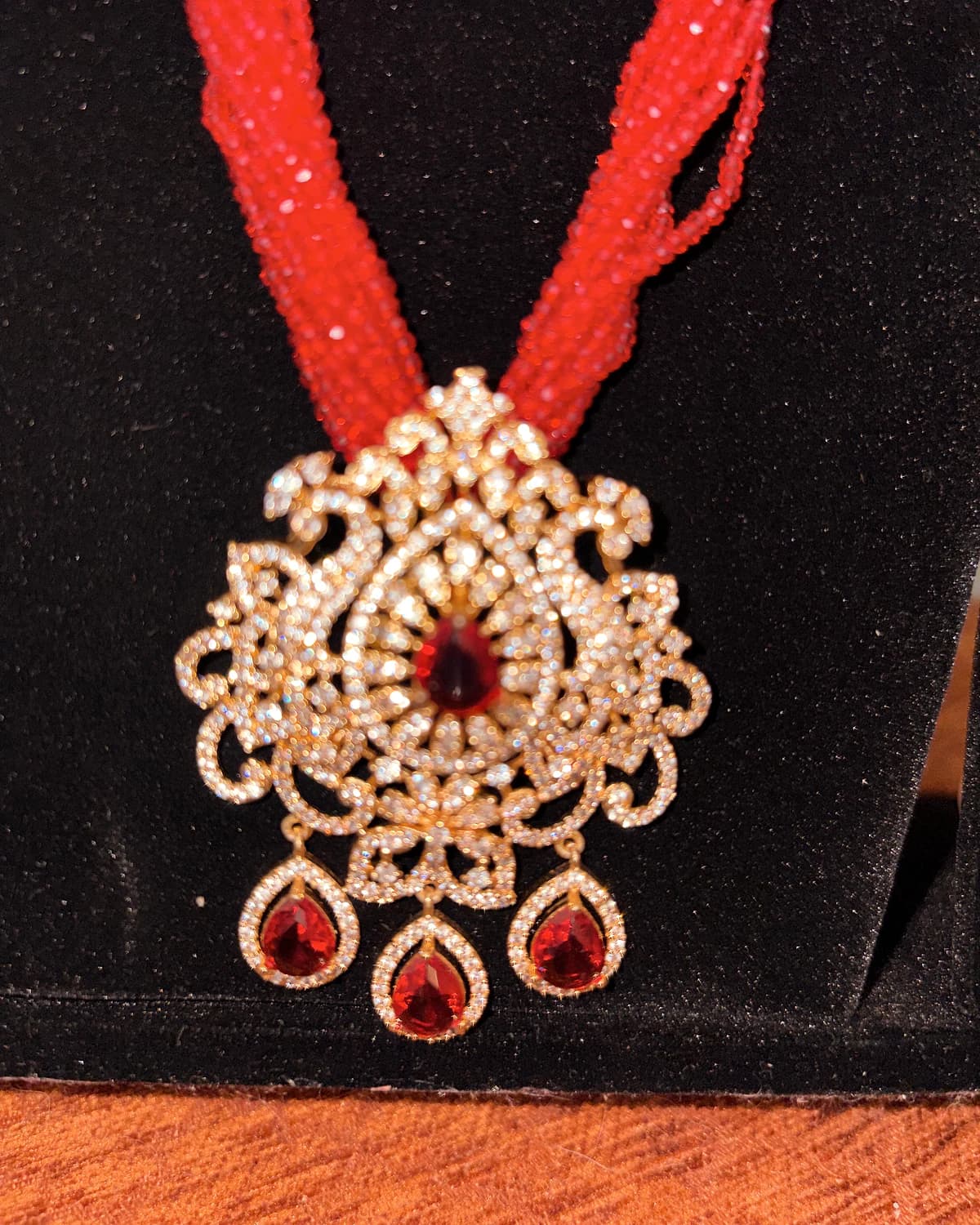 Close detail of the crystal-set pendant and red drops