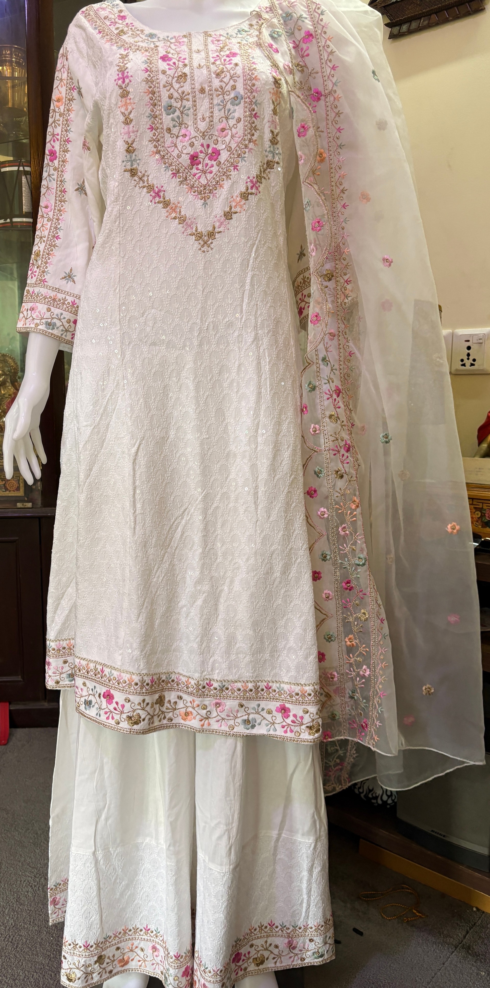 Original ivory floral sharara set on a mannequin with embroidered neckline, trouser hems and floral-bordered sheer dupatta