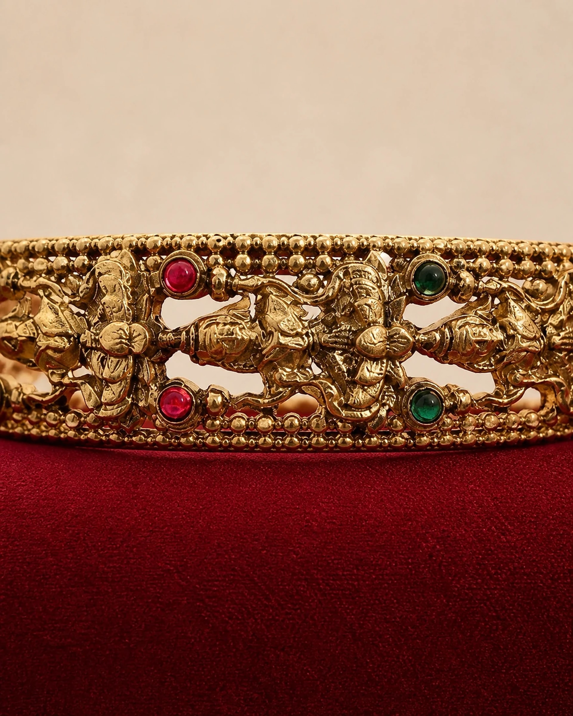 Close detail of the raised figures and coloured stones on the bangle
