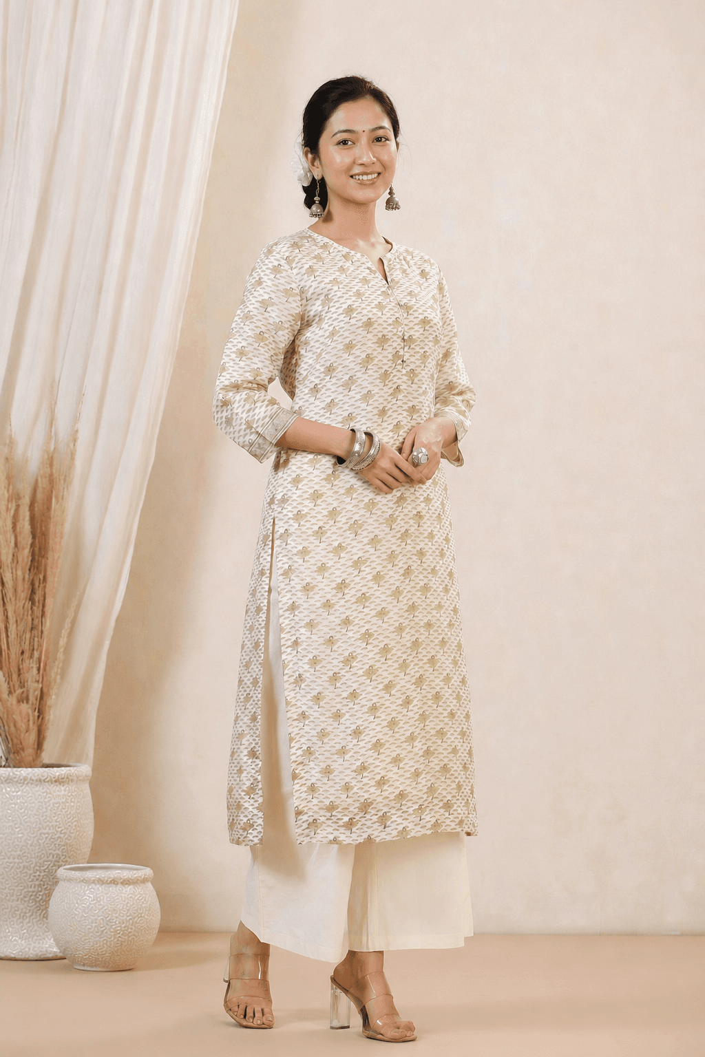 Nepali woman wearing an ivory and gold printed kurta suruwal set